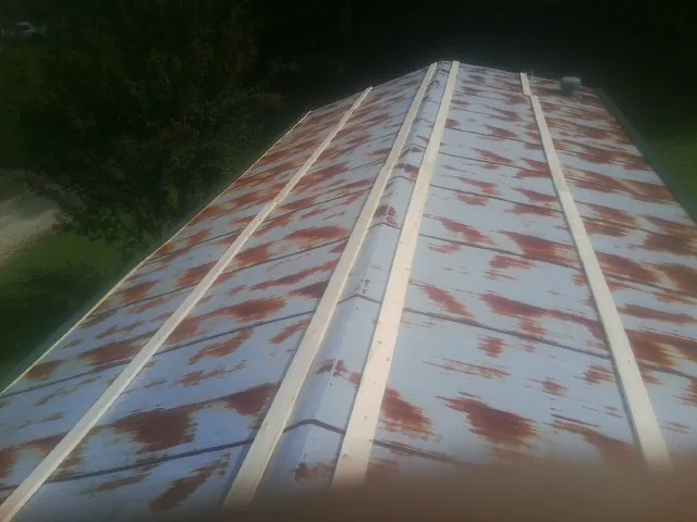Rusted metal roof panels with new wood purlins before replacement — Storm Damage Roof Repair in Alkol by Roofing Brothers
