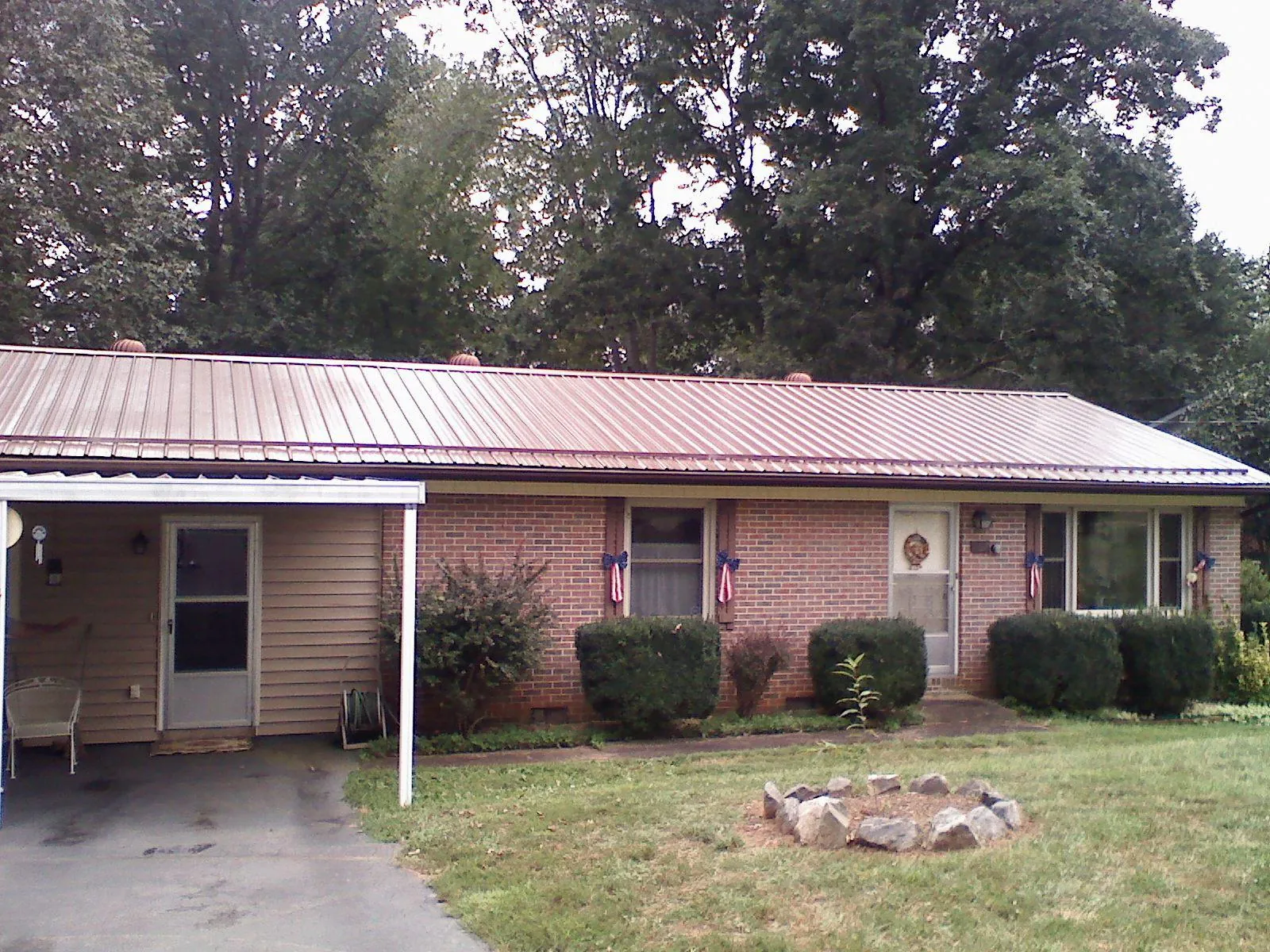 Bronze metal roof and carport on a brick ranch home — Roof Repair work by our crew in Alkol