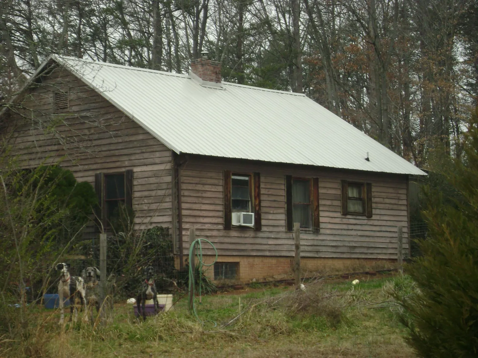 White metal roof on an old wood sided farmhouse, from a Metal Roof Installation job in Alkol